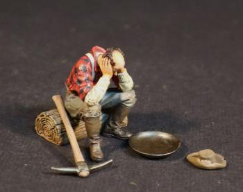 “The End of a Long Day”, The Gold Rush--single prospector figure seated on log, pickaxe, pan, hat #52065