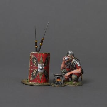 Image of Roman Soldier Cooking--crouching figure and Imperial red shield with two leaning spears and cooking stove with frying pan #52086