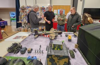 People talking in front of table with models